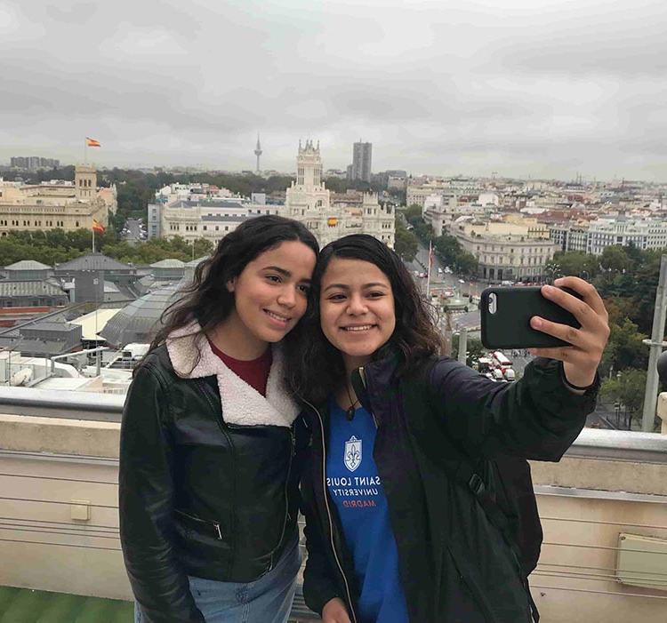 two girls take a selfie in 马德里 overlooking church in distance